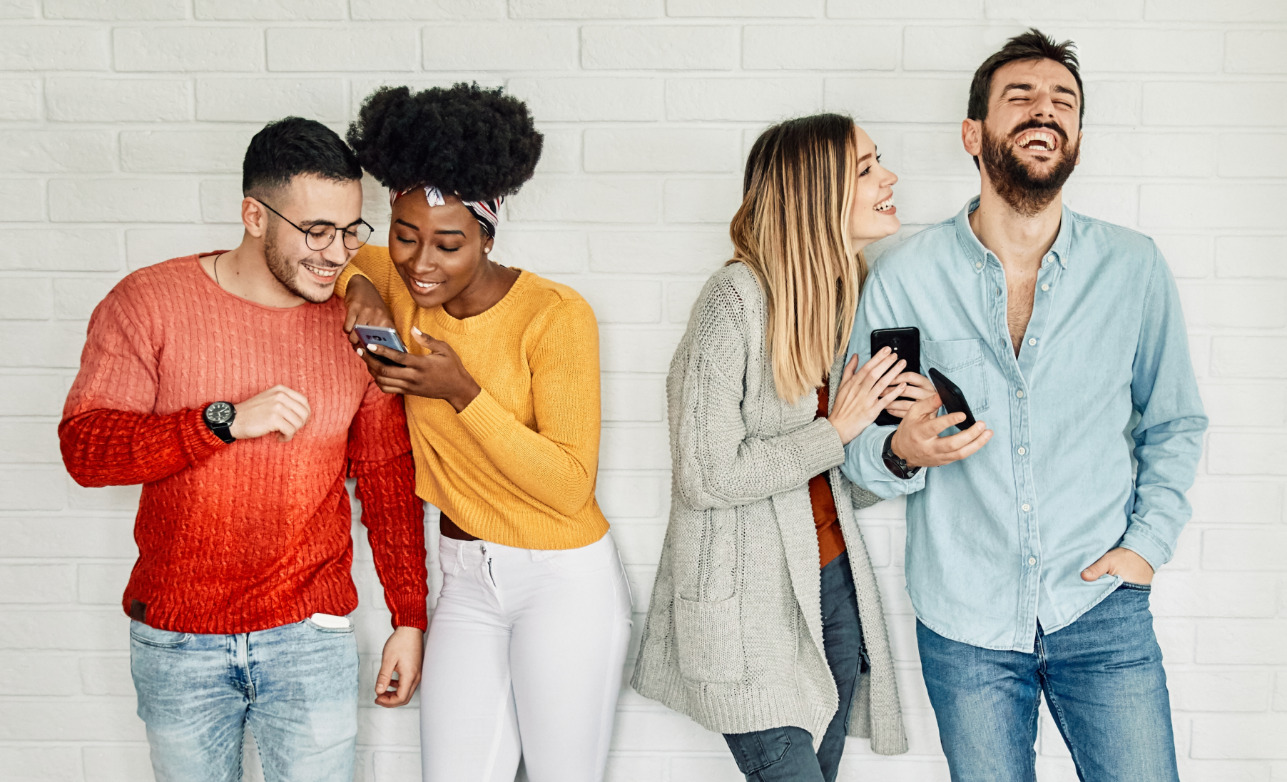 group of people looking joyful while watching their smartphones
