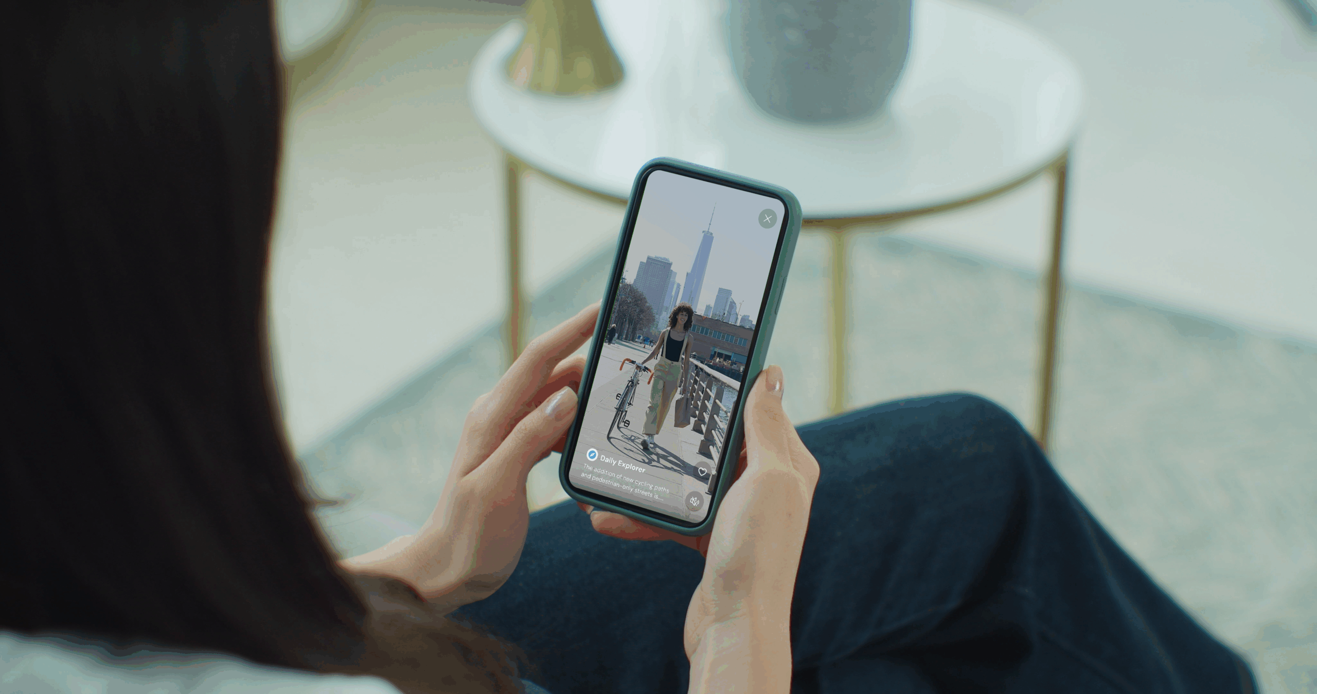 woman looks at a short-form vertical video on her smartphone screen